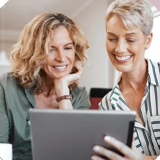Zwei Frauen schauen gemeinsam auf ein Tablet
